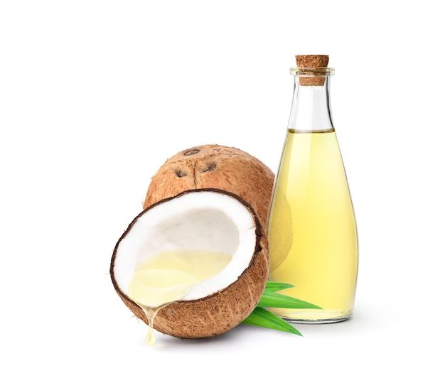 Coconut oil dripping from coconut cut in half with bottle isolated on white surface _ Premium Photo
